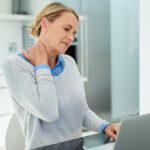 Woman with a sore neck or neck pain from text neck