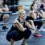 Muscle building workout - woman doing squats with a barbell